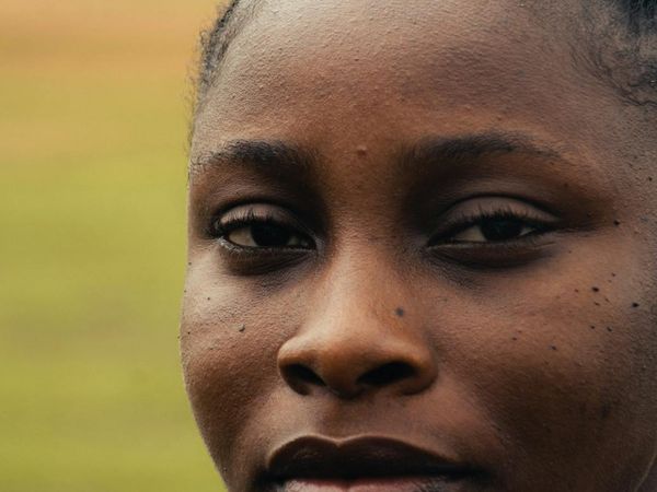 Close-up of a person's serene face with eyes closed, focusing on breath.