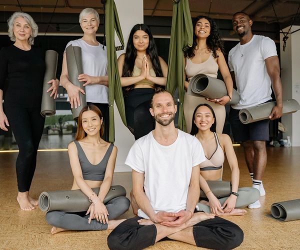 Diverse group of people smiling during a yoga class.